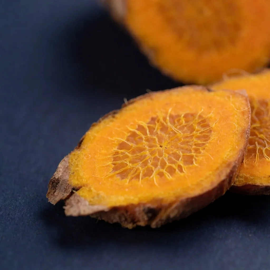 Macro photograph of turmeric root on a dark surface